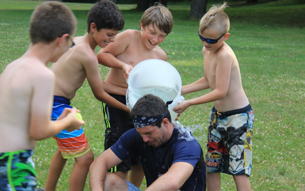 Kids dousing a counselor at camp