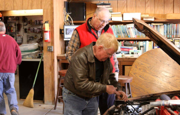 Image of two men working on an automobile.