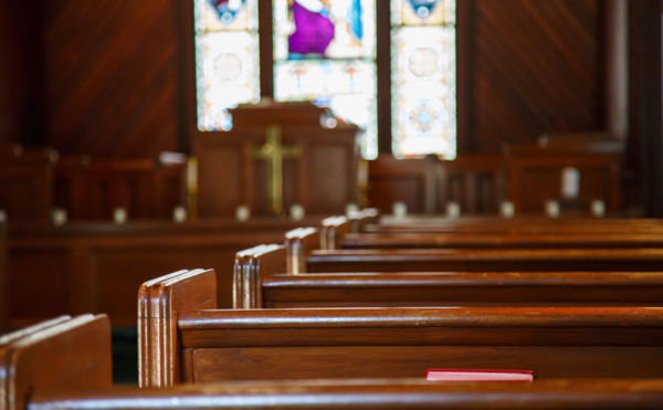 Stained glass windows in small church with wood pews