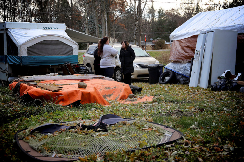 UMCOR case managers speak with a homeowner living in a tent.