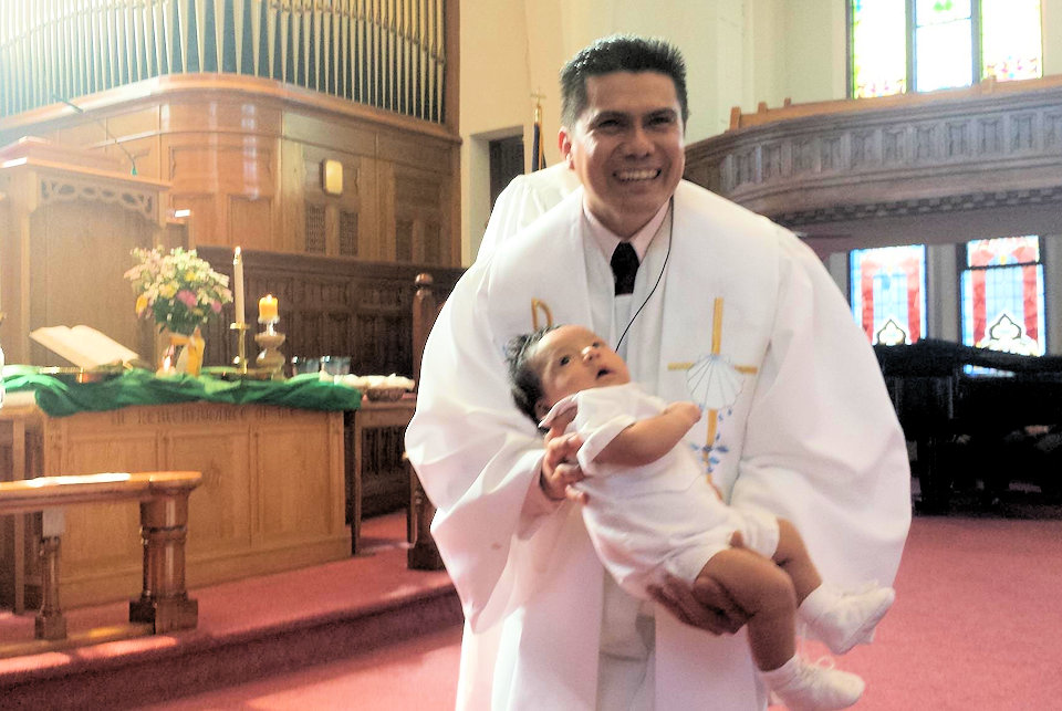 Rev. Rey Mondragon baptizes an infant at BIrch Run UMC.