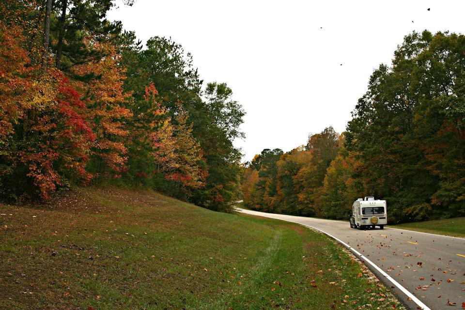 RV traveling down the road in autumn.