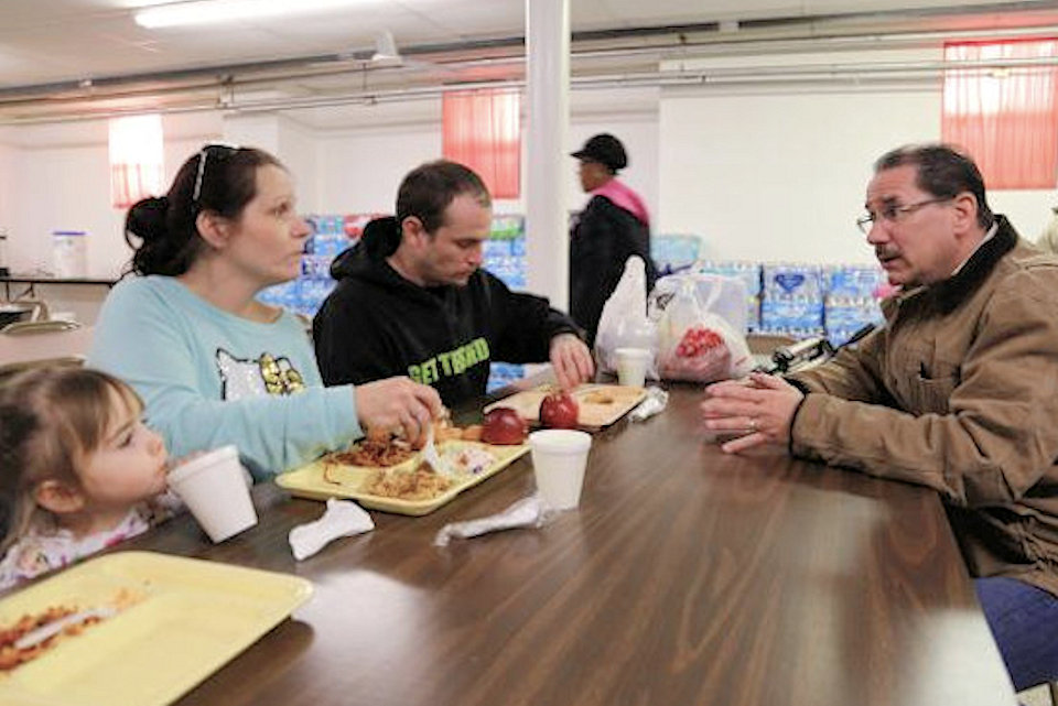 Peter Plum explains water filters to Flint family