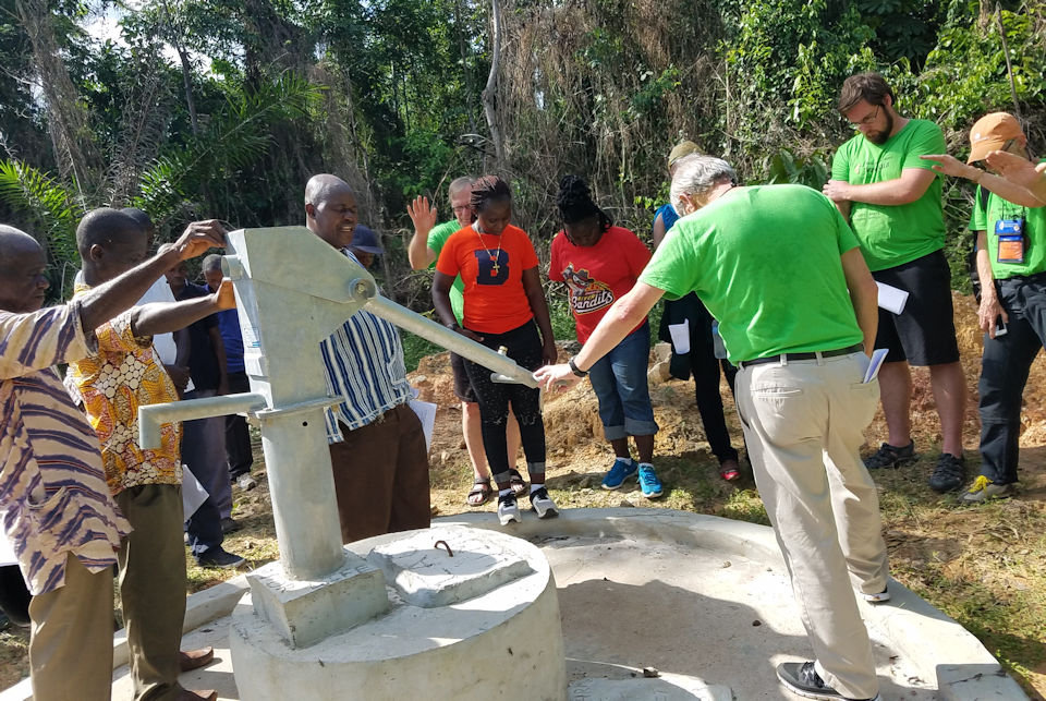 Liberians and Michigan VIMs holding hands and dedicating a well in nohor of Billie Rench.