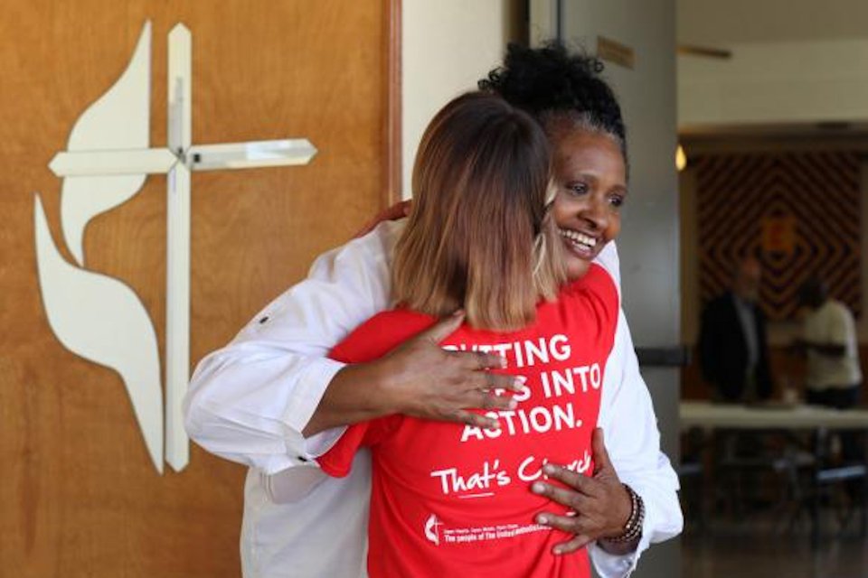 Greeter giving a woman a warm hug.