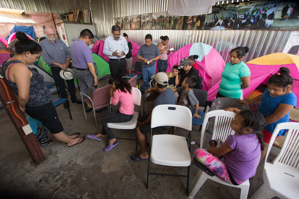 Methodist Bishop of Mexico prays with migrants in center in Tiajuna. Mexico.