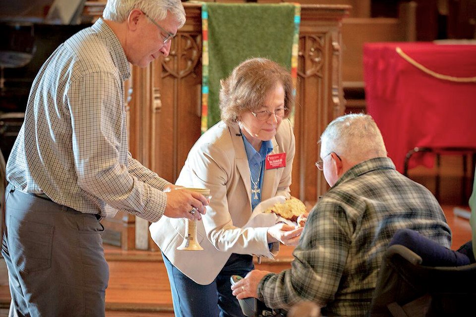 District Superintendent Elizabeth Hill serves Communion