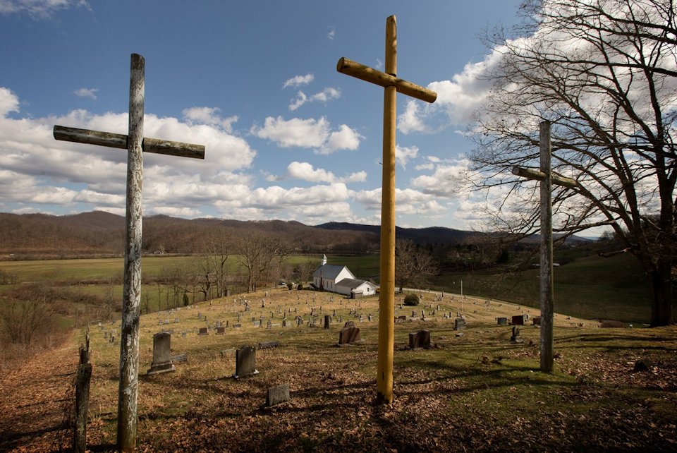 Three crosses stand above a country church