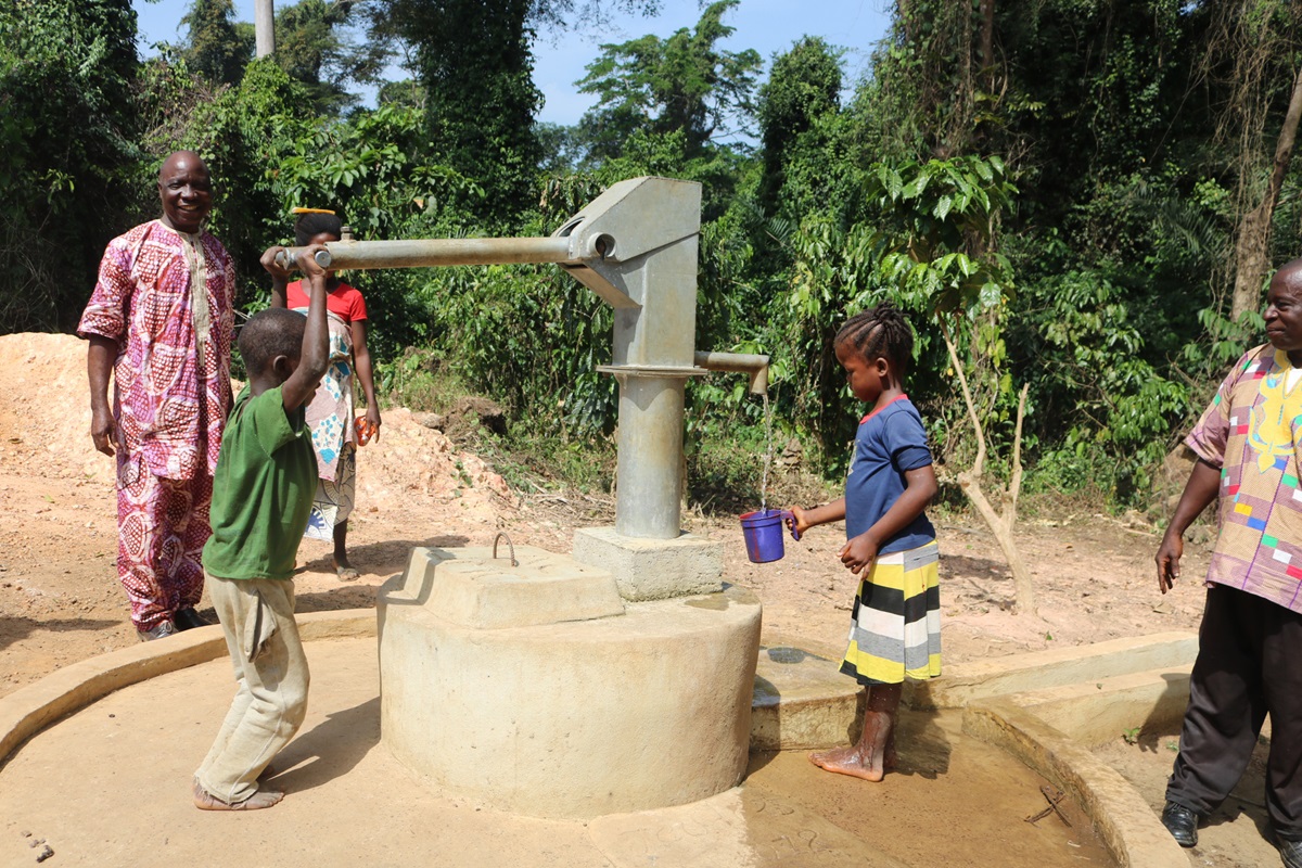 Children pump water in Guinea