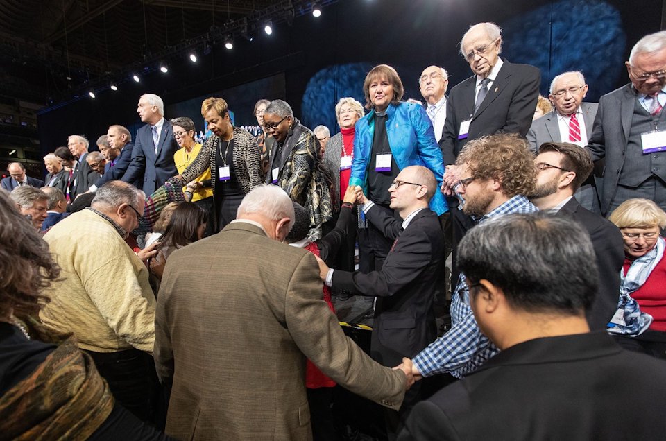 Delegates and Bishops pray together during 2019 General Conference.