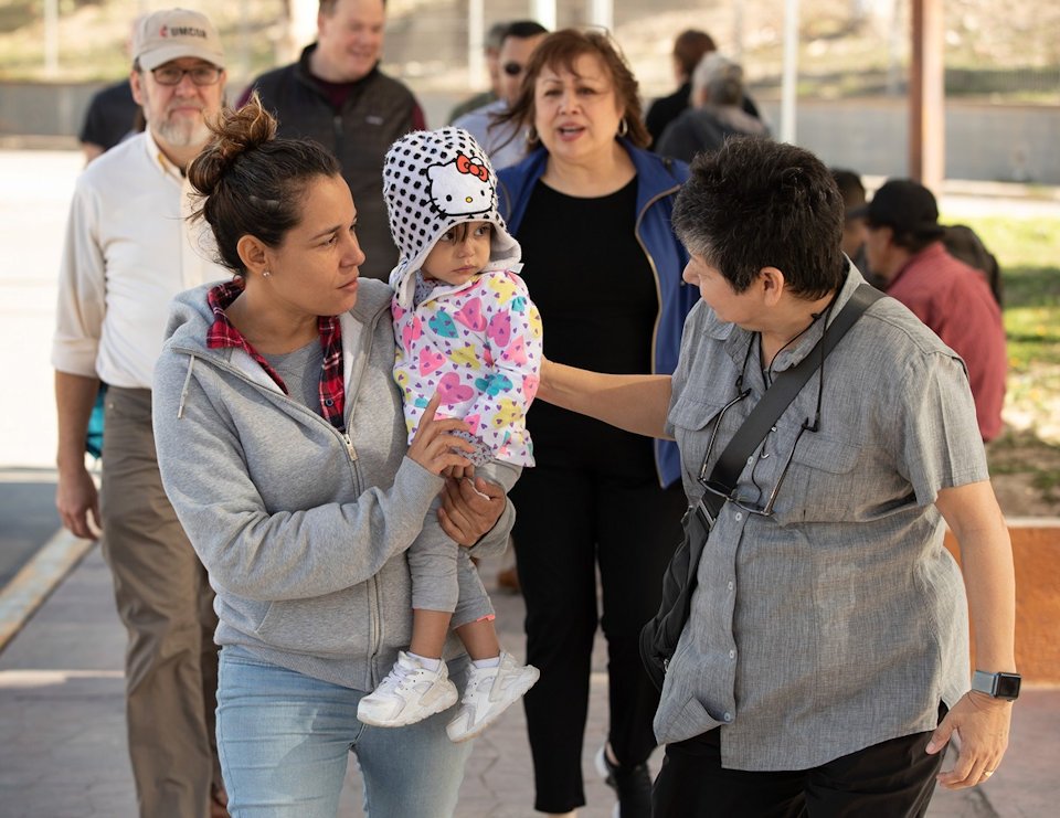 Deaconness at the US-Mexican border with mother and infant.