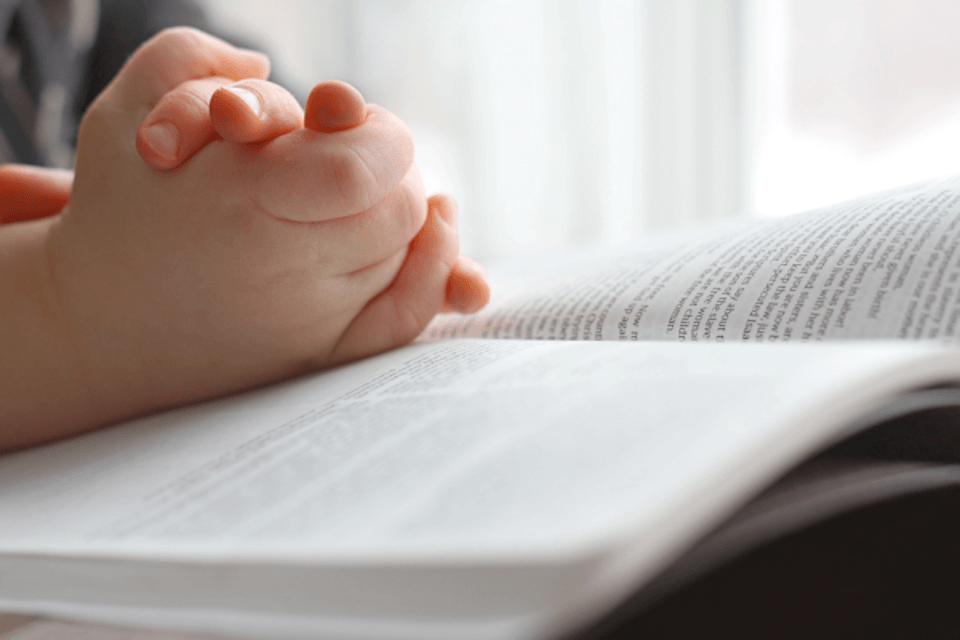 Child's hands on a Bible