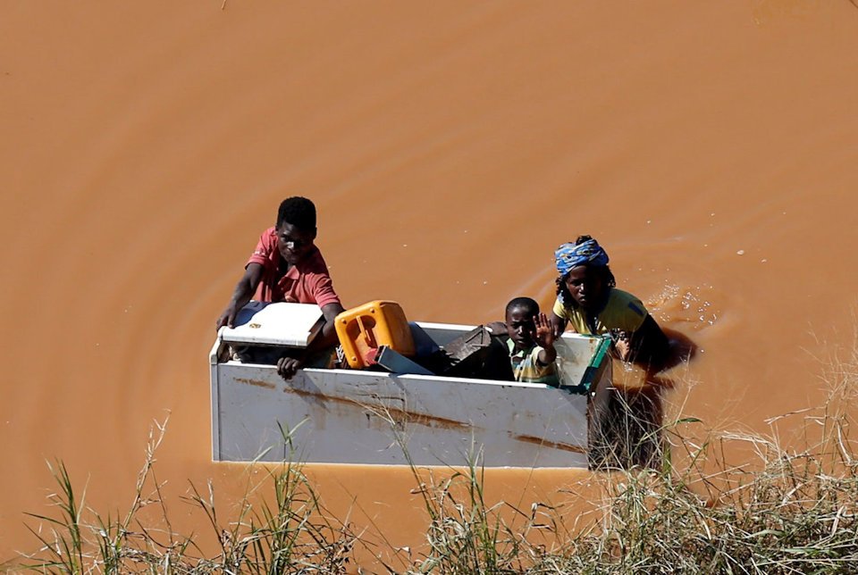 Family in a box floating on flood waters