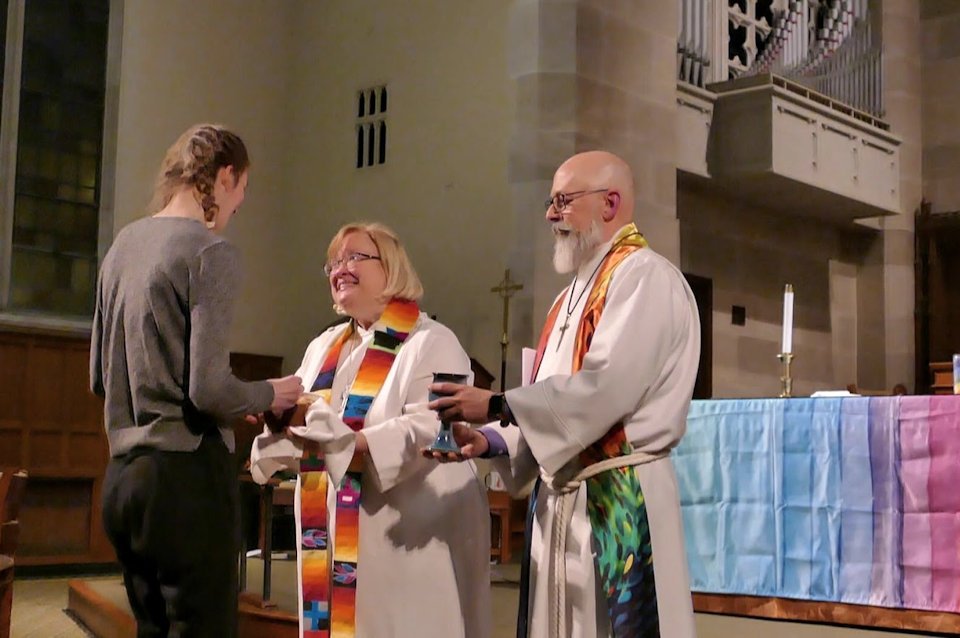 Pastors serve communion to a young woman