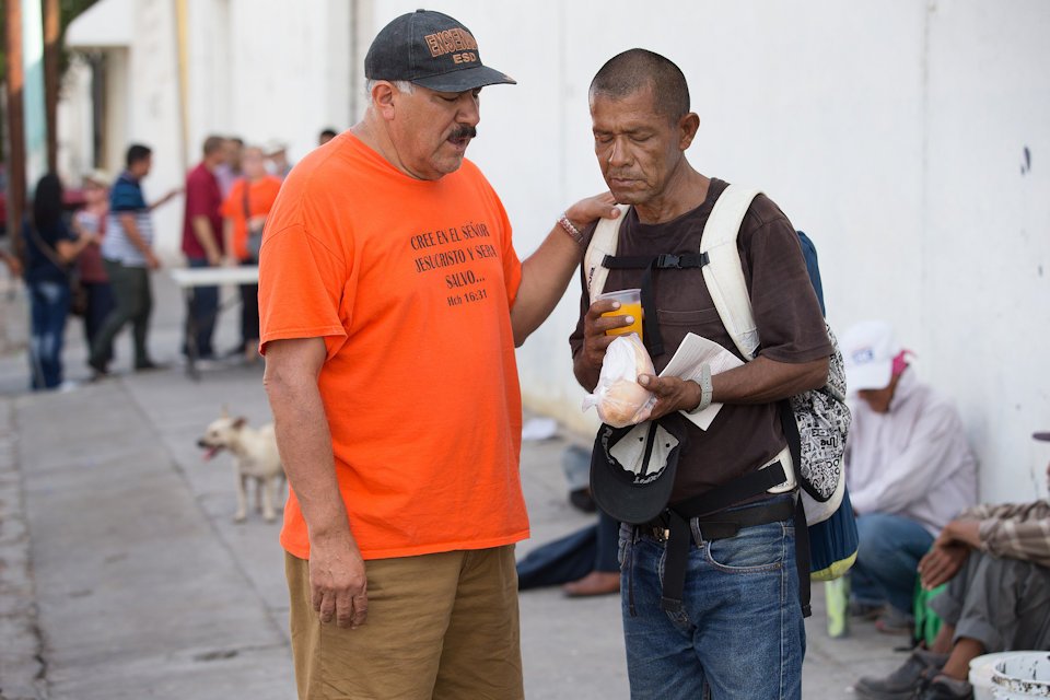 Man praying with Mexican migrant 