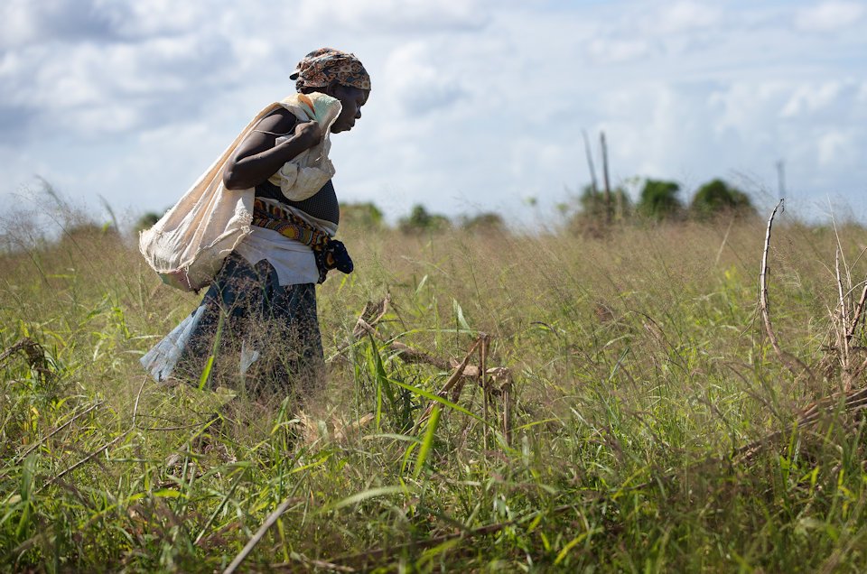 Woman in field ruined by cyclone.