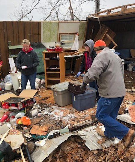 Volunteers sift through tornado debris.