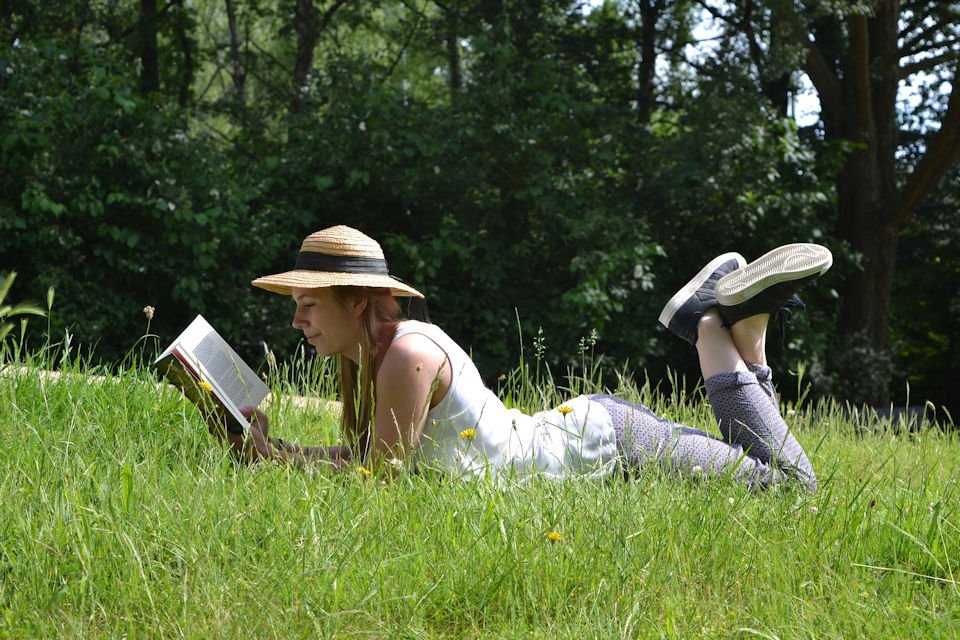 woman reads in the grass