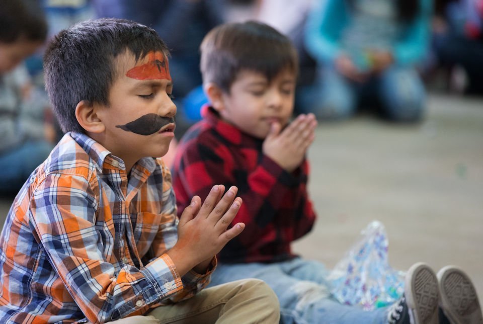 Children Pray at migrant center in Tijuana. Advocacy needed.
