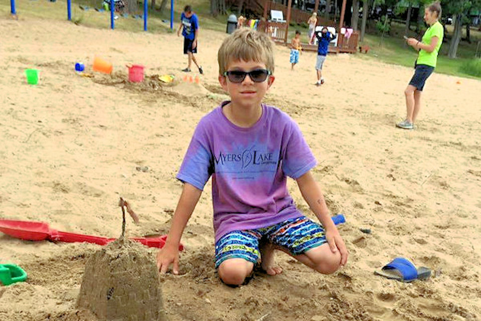 Boy playing in sand at Myers Lake camp site