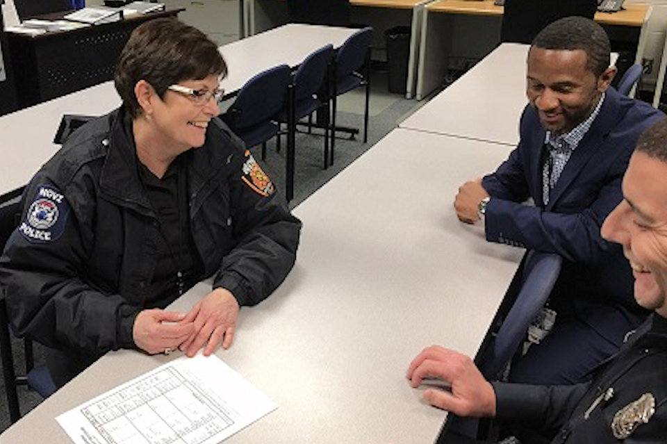 Police chaplain chats with others.