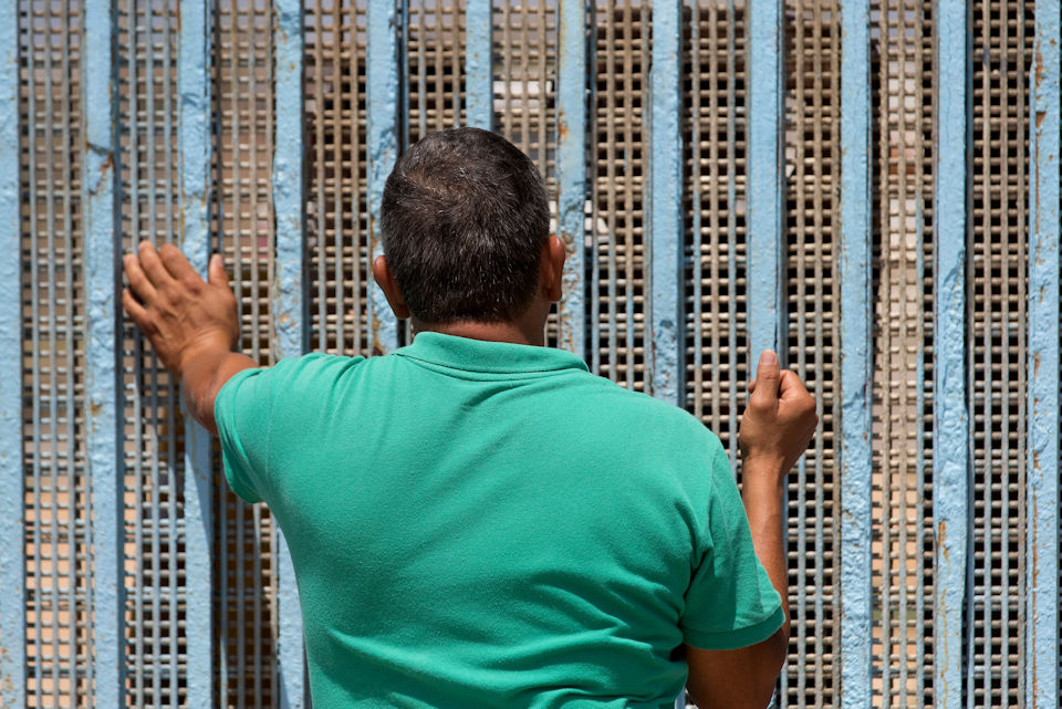 Man standing at the wall in Tijuana, Mexico.