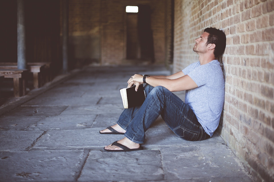 Man experiences loneliness up against a wall