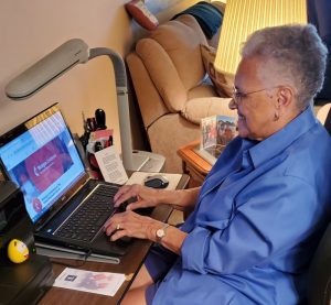 Photograph of Phyllis Jackson sitting at her laptop.