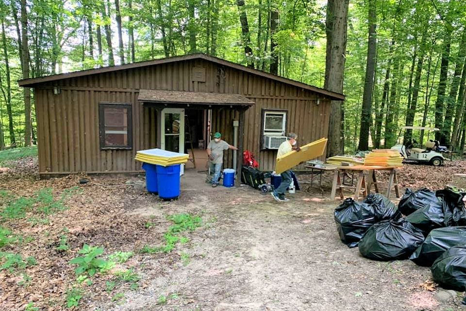 Volunteers clean a cabin