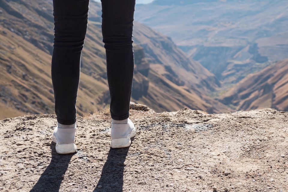 Woman on cliff overlooking valley.