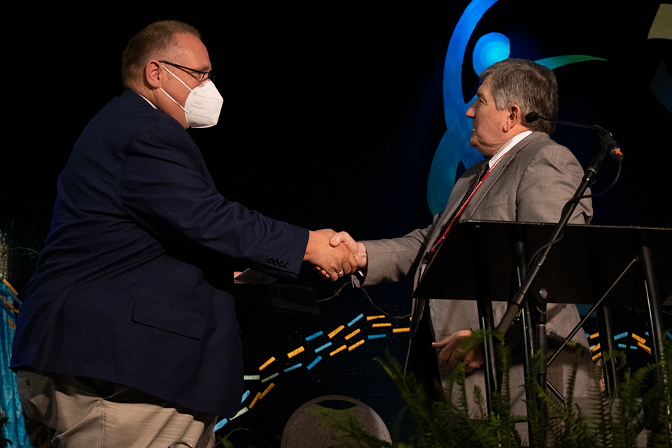 Craig VanBeek receives the Harry Denman Evangelism Award from Dirk Elliott.