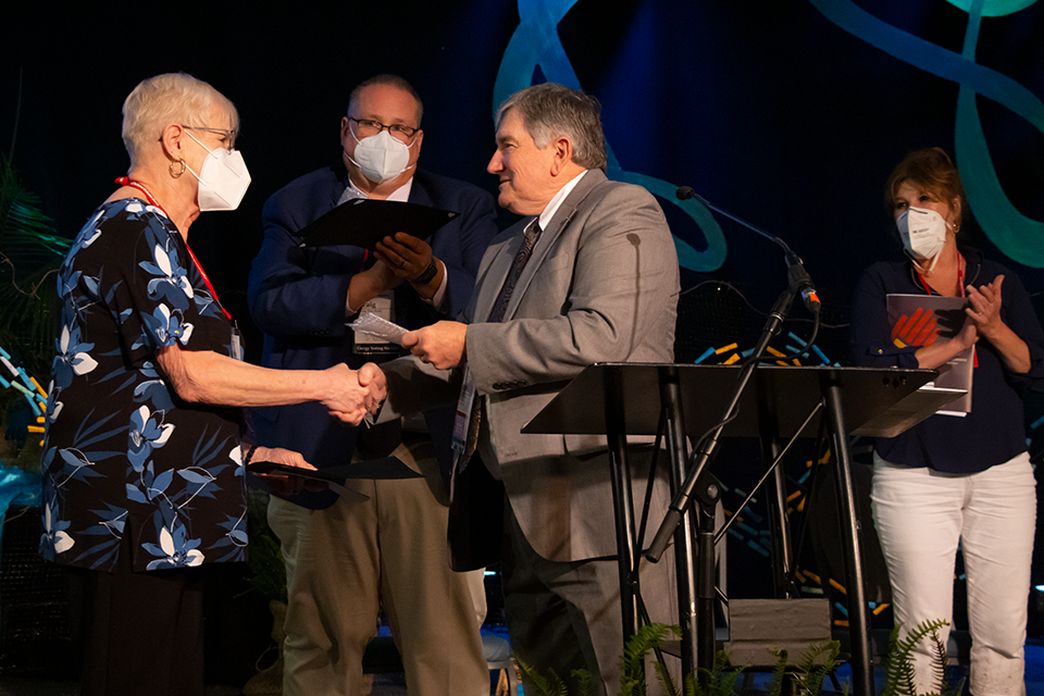 Michele Weston receives the Harry Denman Evangelism Award from Dirk Elliott.