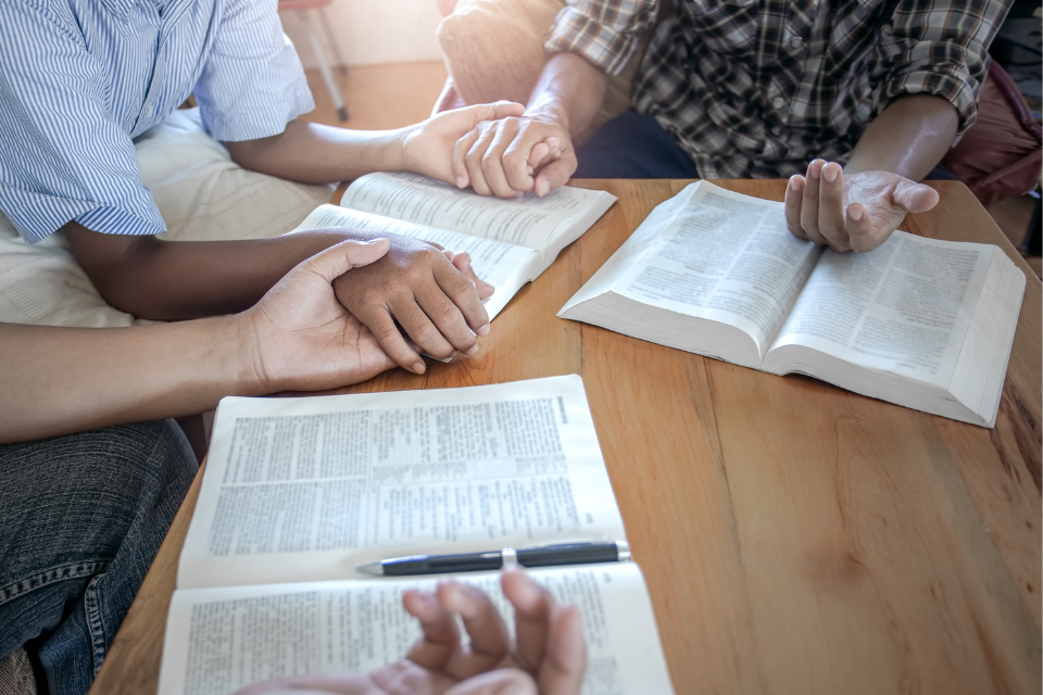 Holding hands in prayer during Bible study.