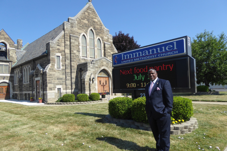 Rev. Albert Rush standing in front of his church.