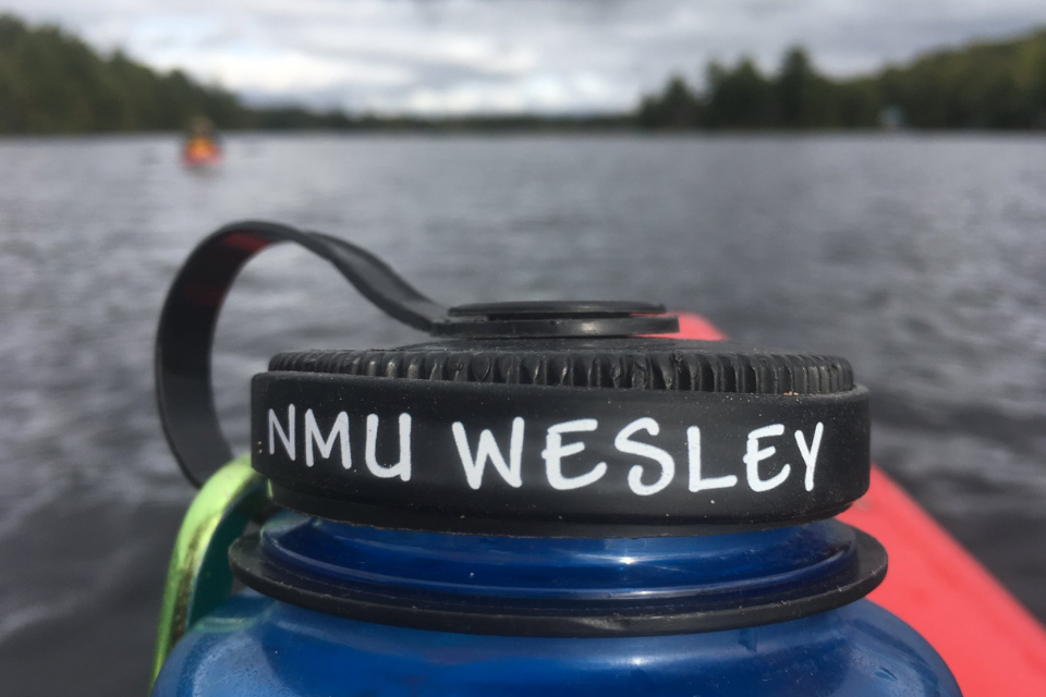 Water bottle with NMU Wesley printed on it.
