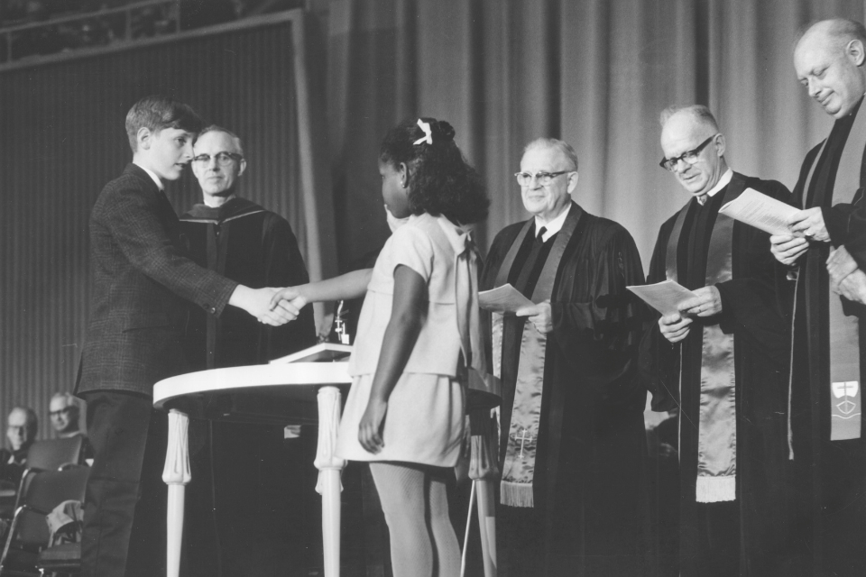 Two children shake hands to symbolize the creation of the UMC in 1968.