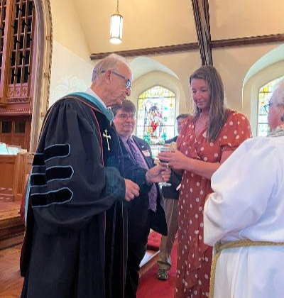 Rev. Lowell Walsworth receiving communion from his daughter.