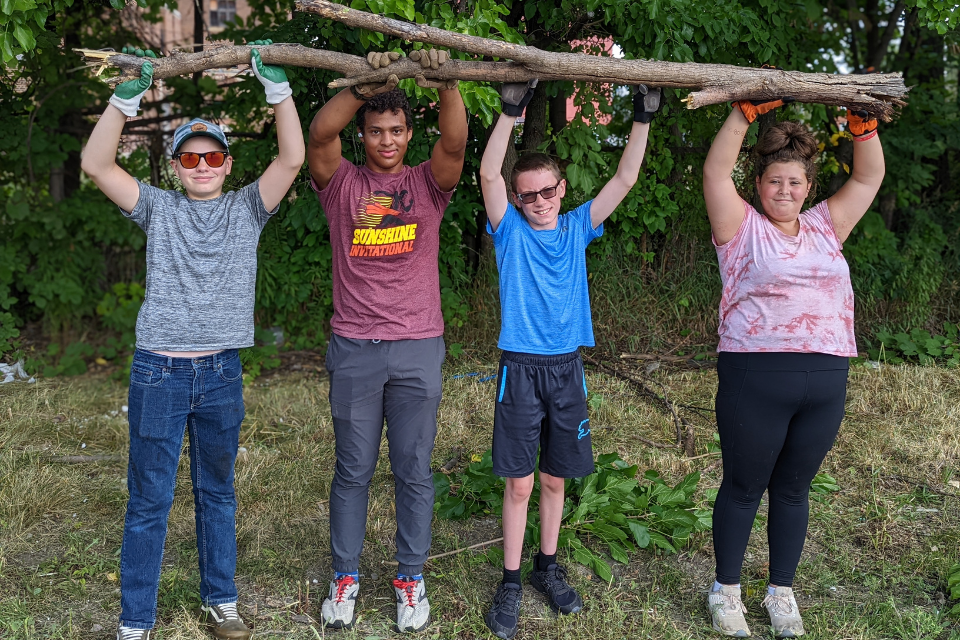 Youth removing tree limbs during a mission trip.