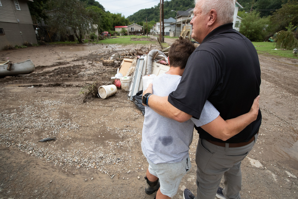 Pastor prays with flood survivor.