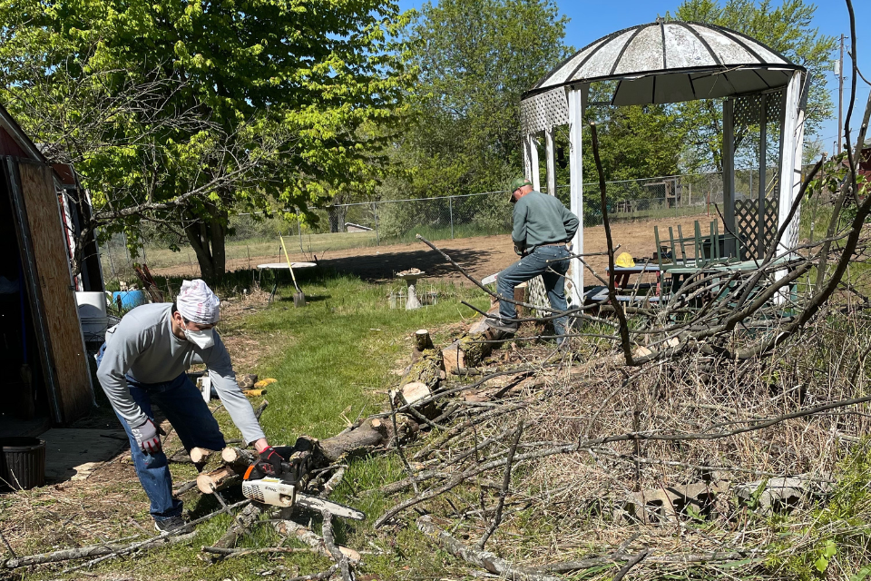 Volunteers cleaning up brush at community garden.