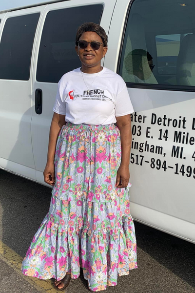 Pastor Gertrude standing next to church van.