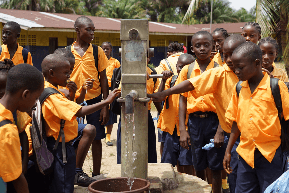 Children at school in Liberia drinking water from a fountain