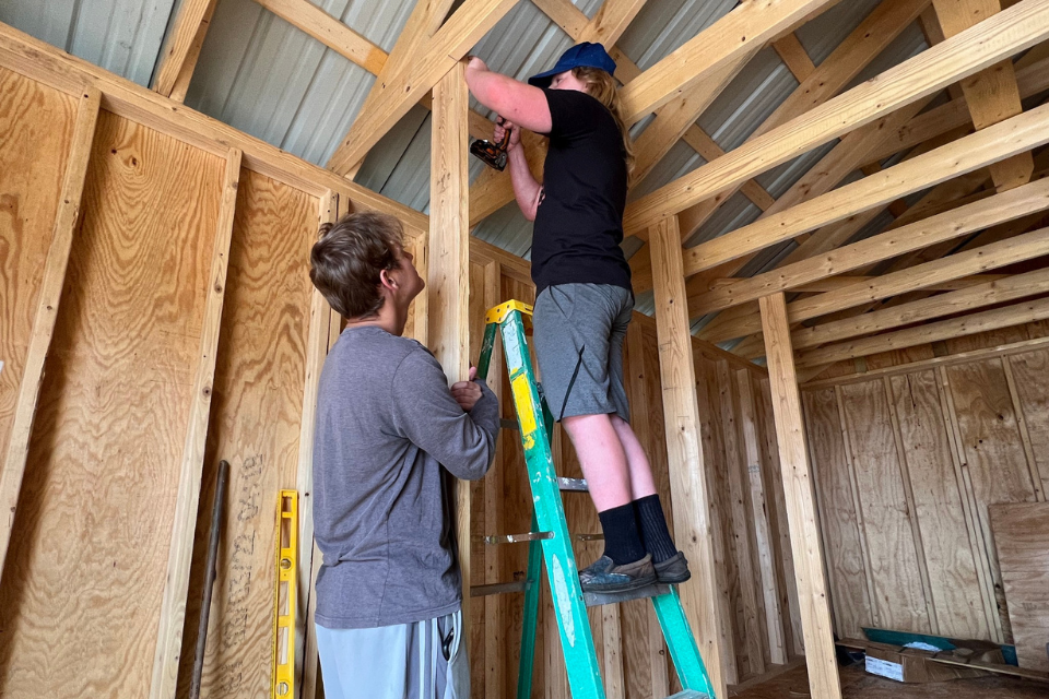 Volunteers working on a storage building