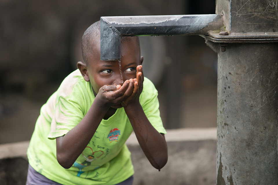 Boy drinking water from spigot