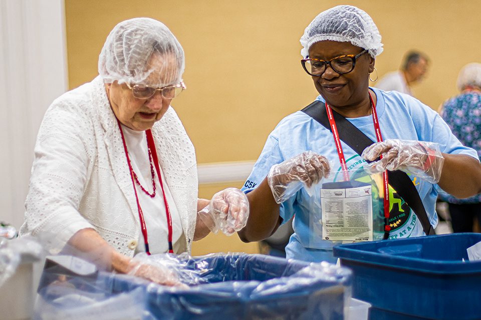 Women filling rice meal packs for hunger relief