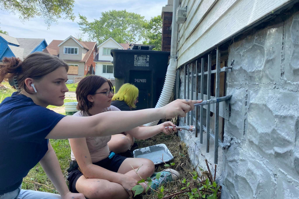 Youth painting a house