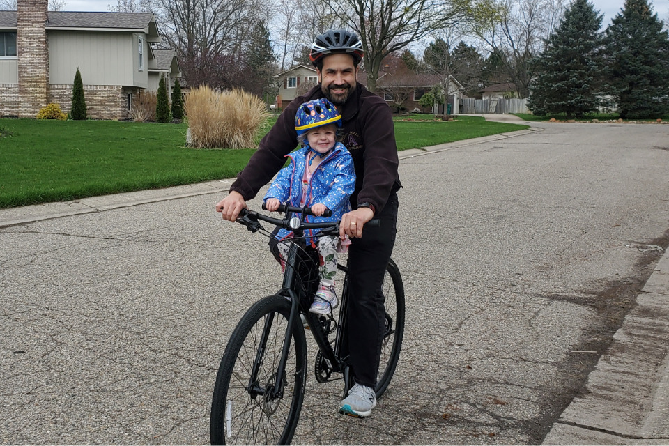 Joel and his daughter riding a bike