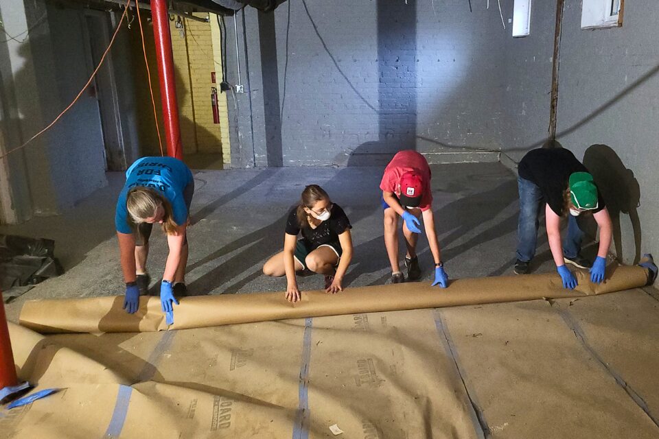 Youth assisting with floor restoration