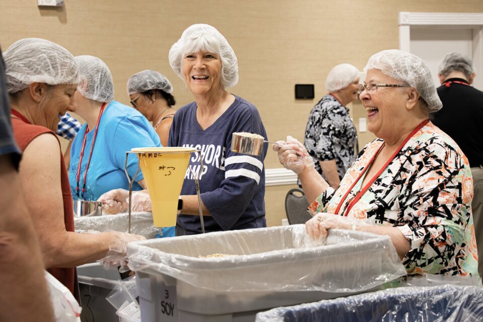 People assembling rice meal packs at Annual Conference