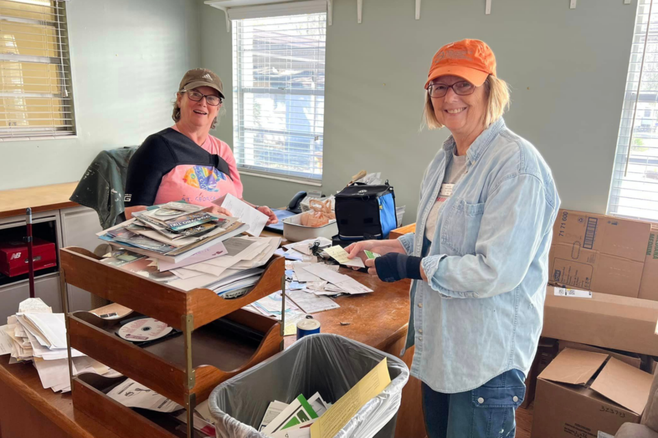 Women sorting through piles of paper